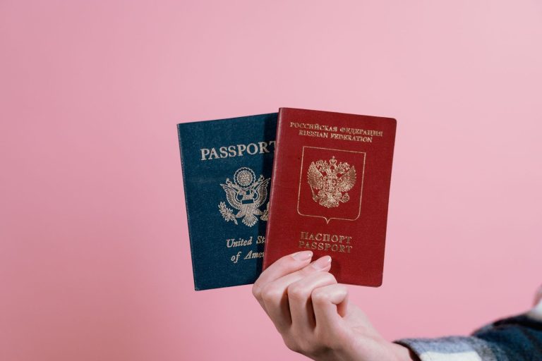 Hand holding American and Russian passports side by side