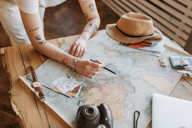 Woman planning an international trip with a world map and passports