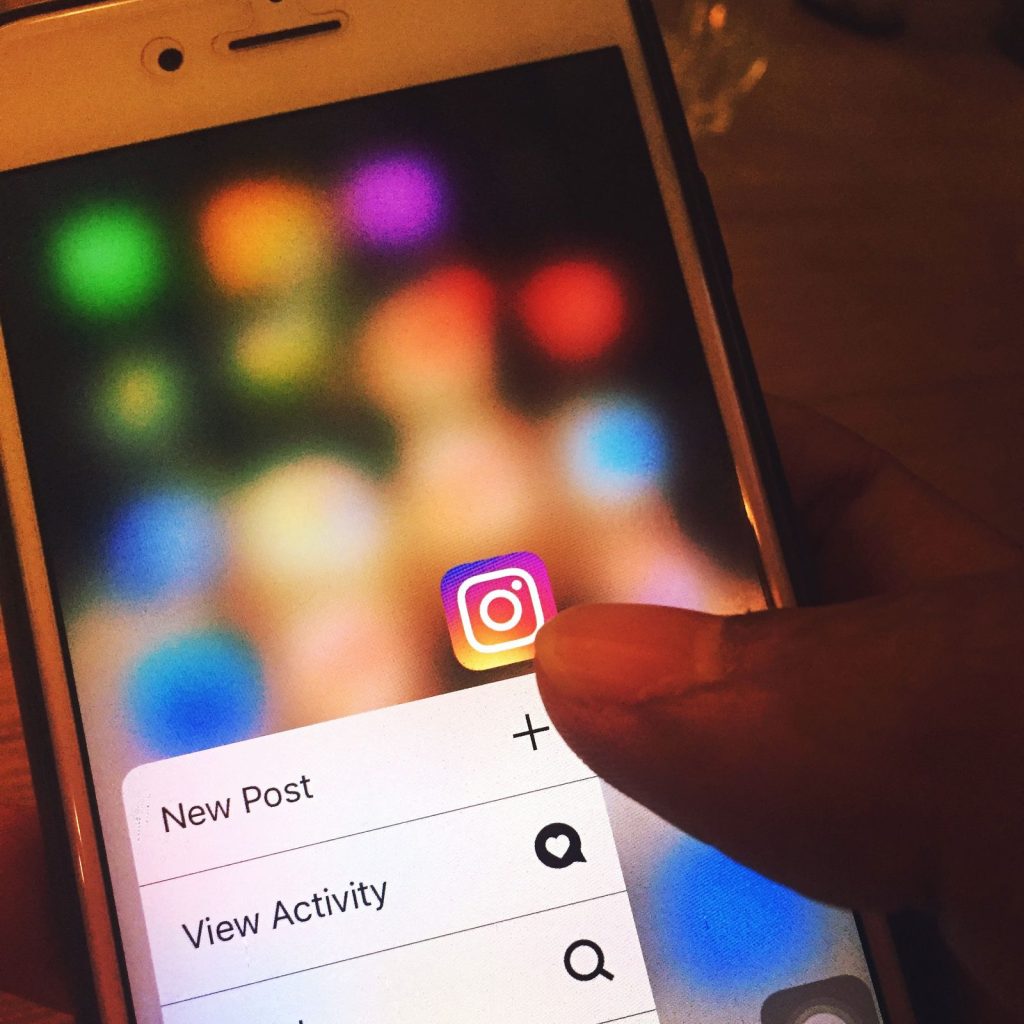 Finger navigating the Instagram app on a smartphone screen