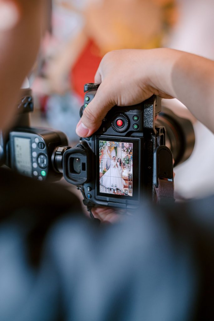 Photographer capturing a wedding scene with a DSLR camera