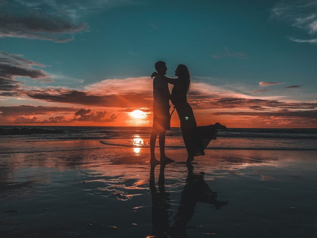 Silhouette of a couple embracing on a Bali beach during sunset