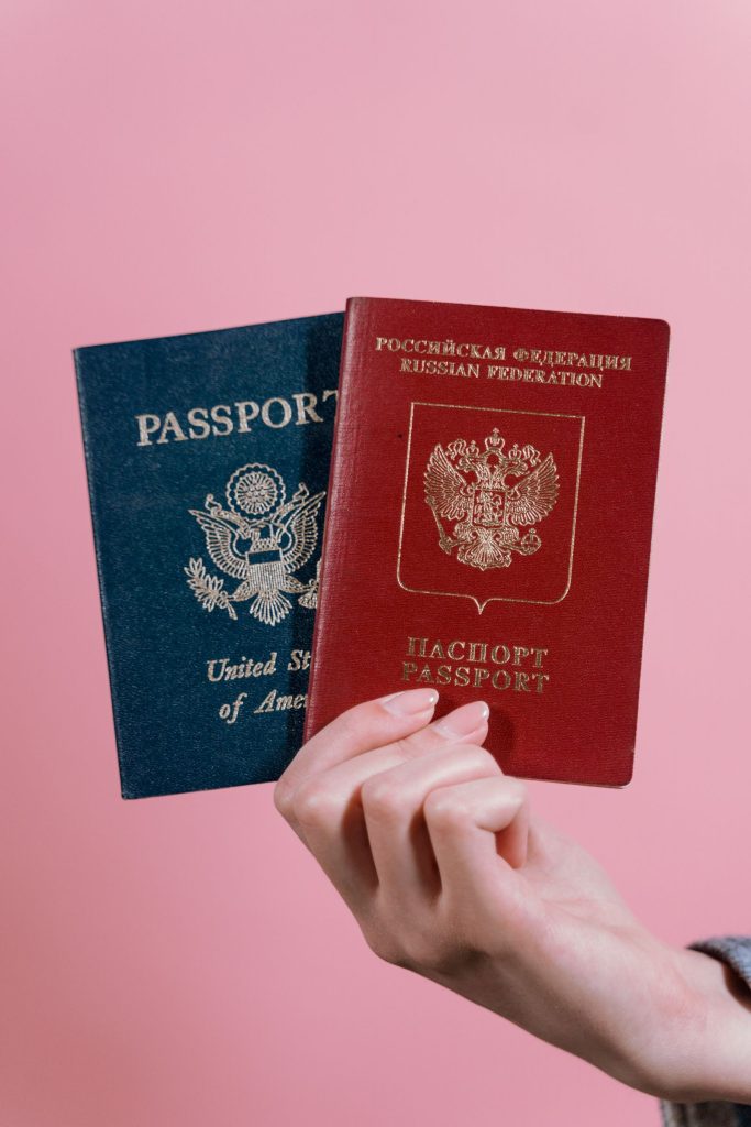 Hand holding two different passports for visa comparison