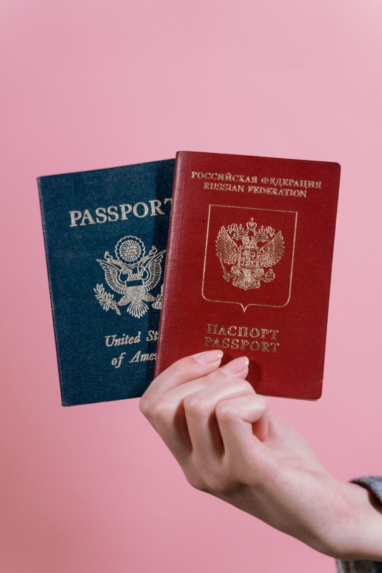 Hand holding two different passports for visa comparison