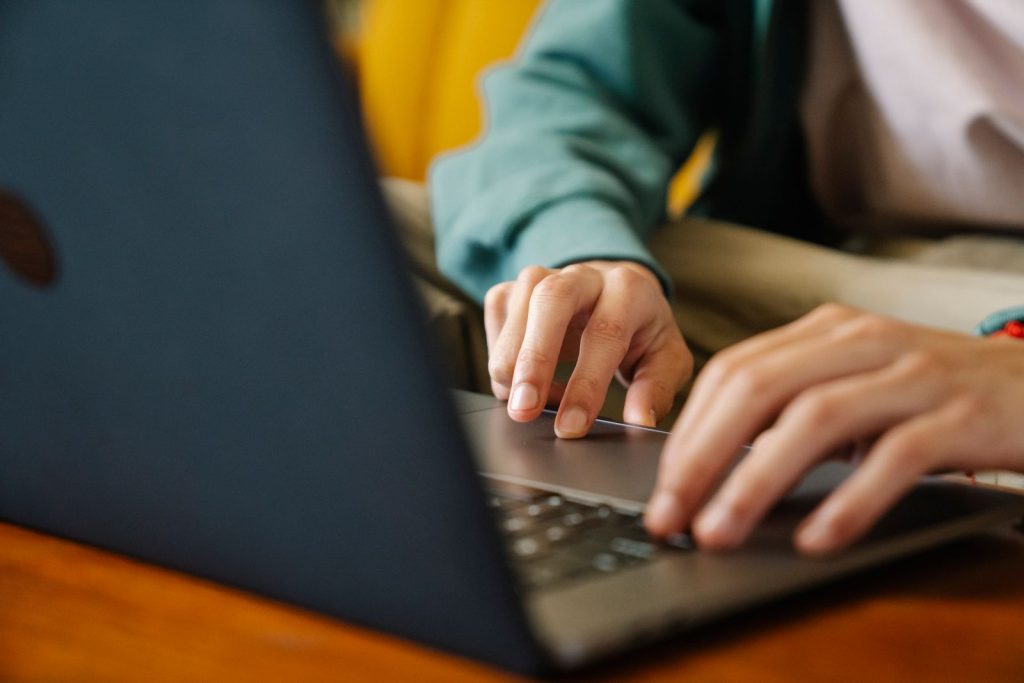 Remote worker typing on laptop to complete an online visa application