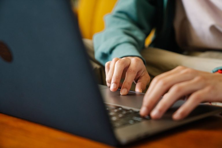 Remote worker typing on laptop to complete an online visa application